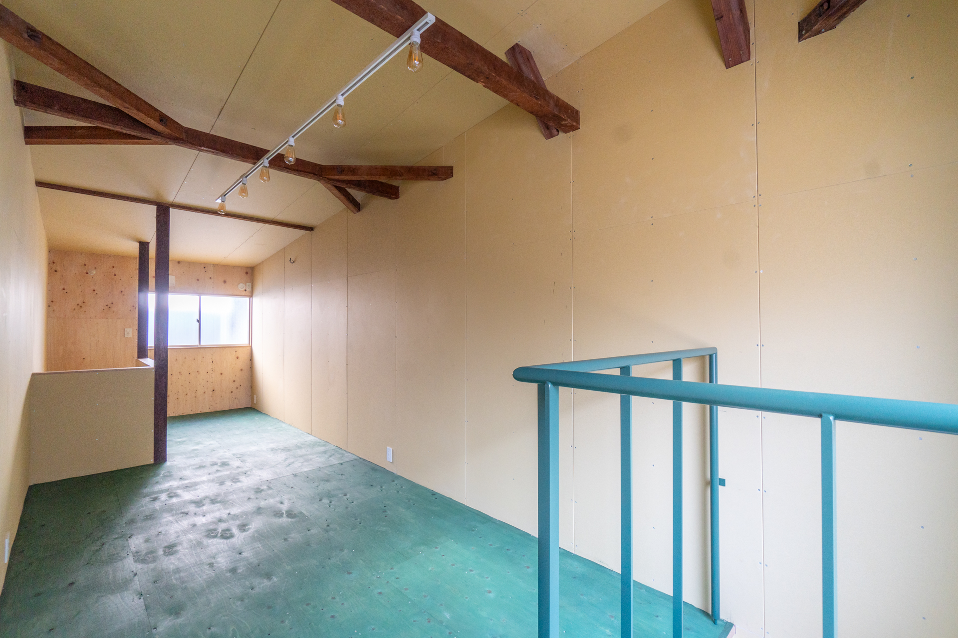 吹き抜けの柵と床材の色味がマッチ