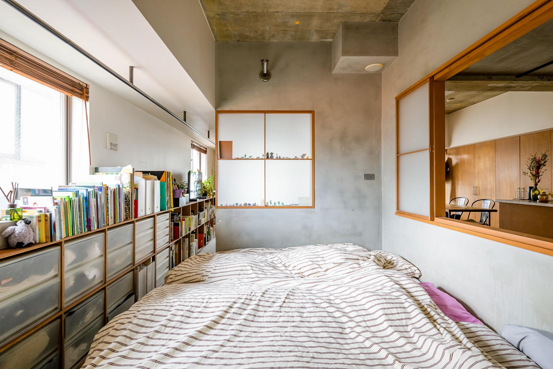 コの字の壁で寝室を仕切り、光と風を通すための室内窓を設置（写真正面の窓はフィックスです）
