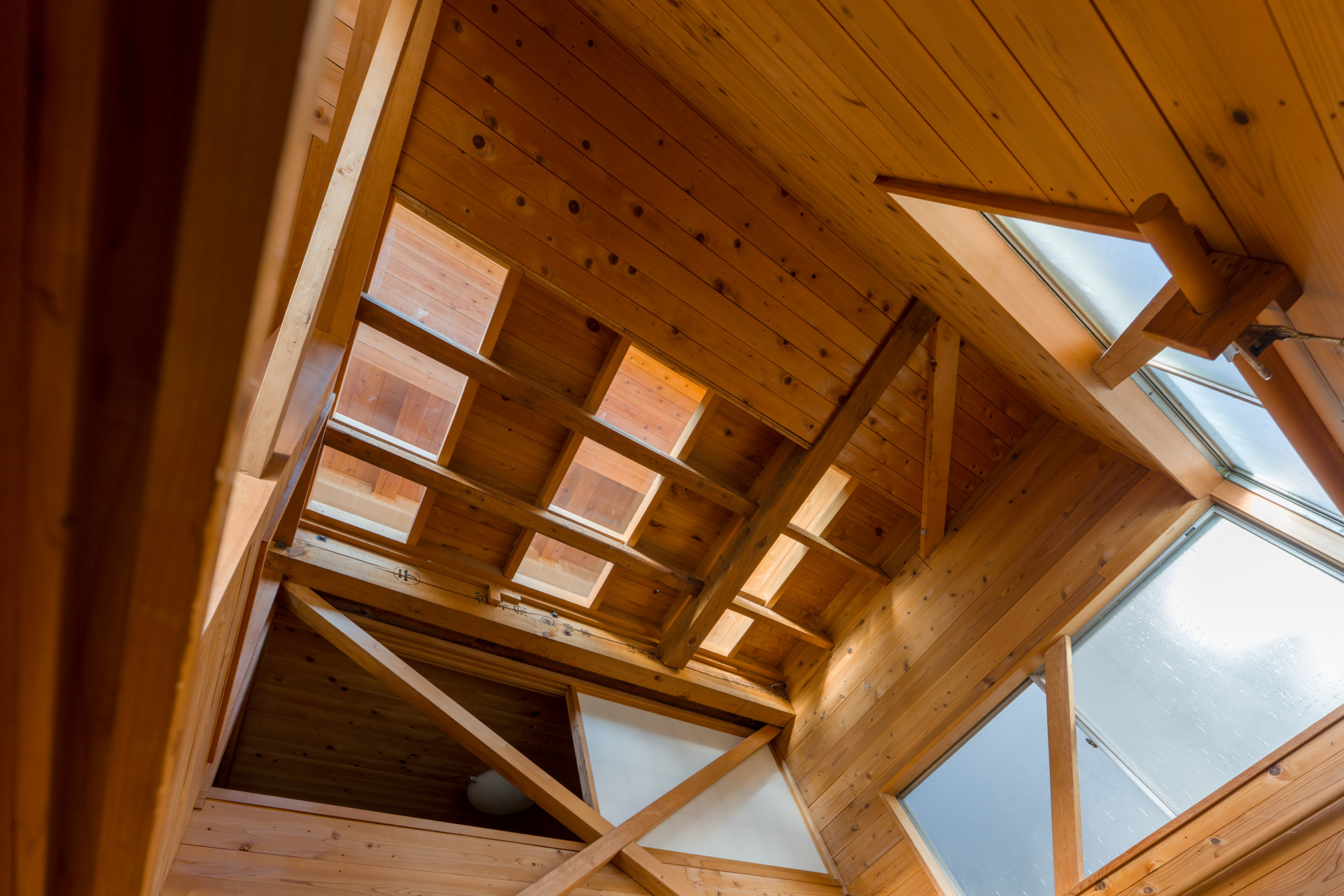 2階の床の強化ガラスから吹き抜けを通じて南向きの光が1階まで差し込んできます