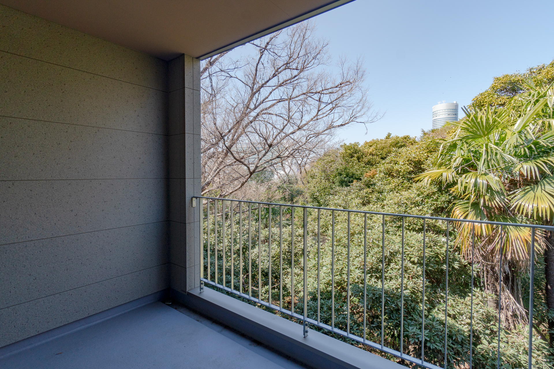 林の奥に新横浜駅のビルが見える
