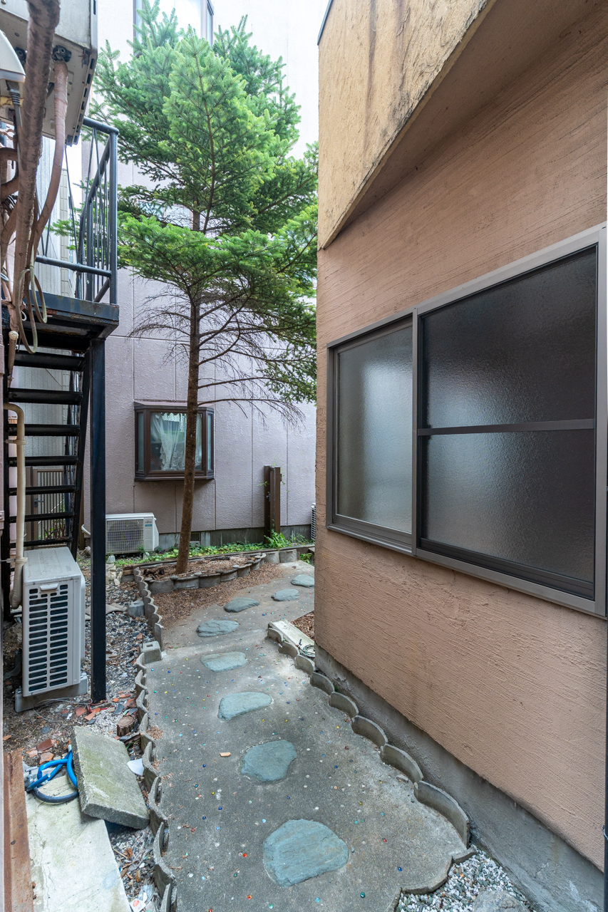 路地を入ってくると建物横を抜けて